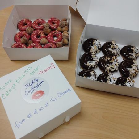 3 boxes of donuts, two open to show chocolate nut icing and pink sprinkle icing, and some donut holes - looks delicious!