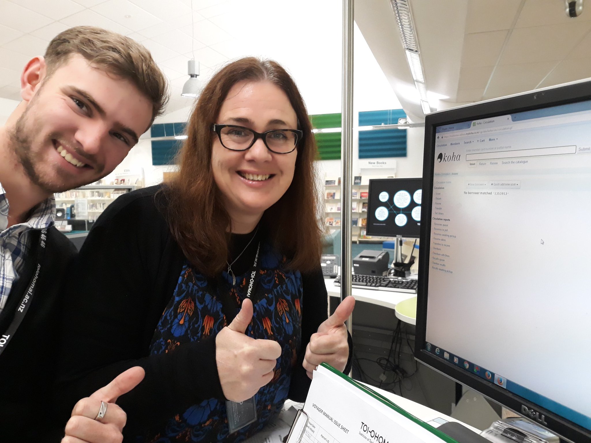 Two Toi Ohomai librarians - an man and woman - smiling and doing thumbs up with their computer now running the new koha system